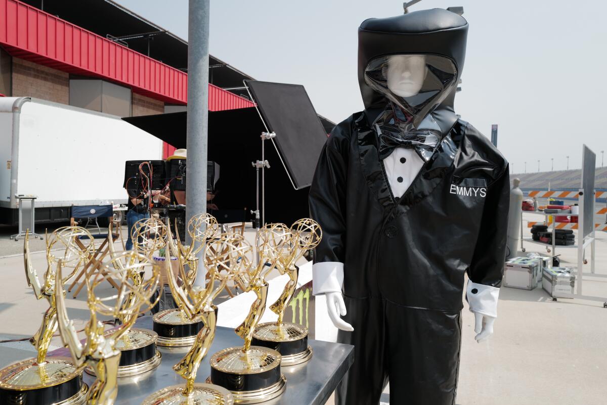 A mannequin in a tuxedo hazmat suit guards over the Emmy statuettes in preparation for the 72nd Emmy Awards.