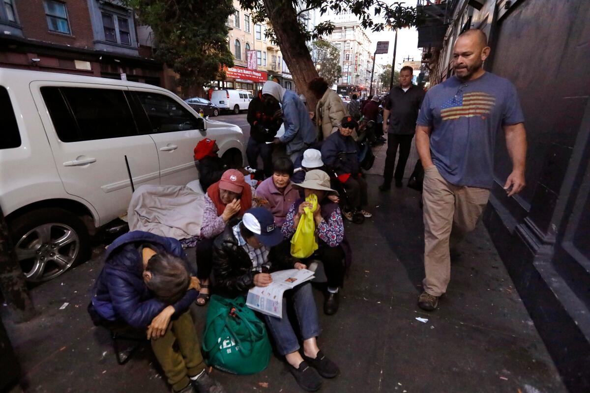 Garrett Hamilton and Lt. Kevin Skaife walk past people in San Francisco's Tenderloin.