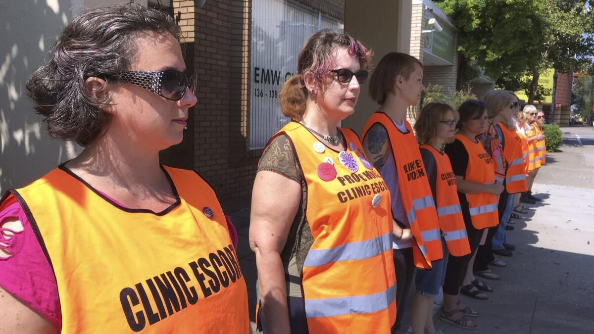 Escort volunteers line up outside the EMW Women's Surgical Center in Louisville, Ky., in July 2017.