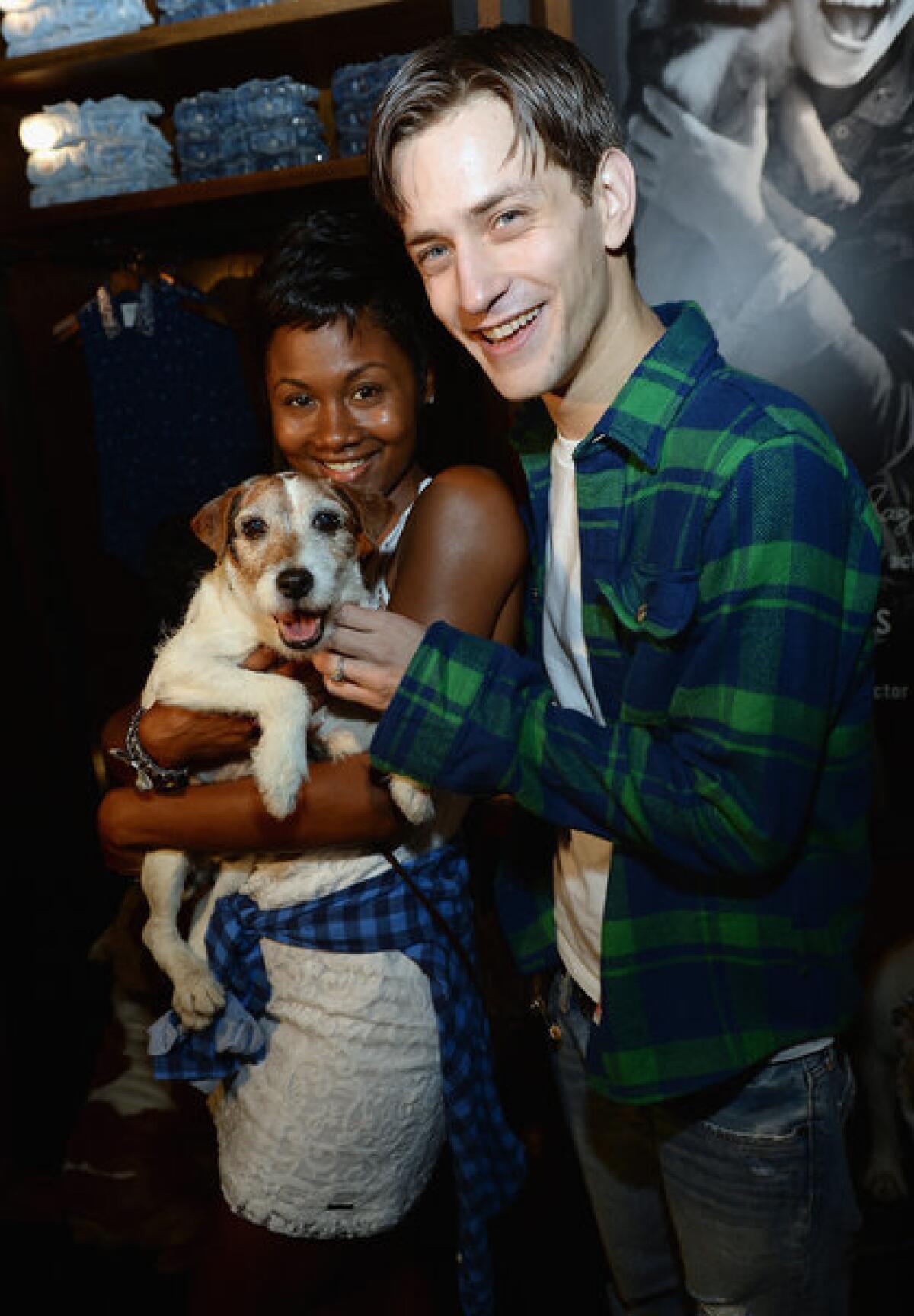 Uggie cuddles with Emayatzy Corinealdi and gets a scratch from Johnny Ferro at the launch of Abercrombie & Fitch's 2013 Stars on the Rise on Thursday.