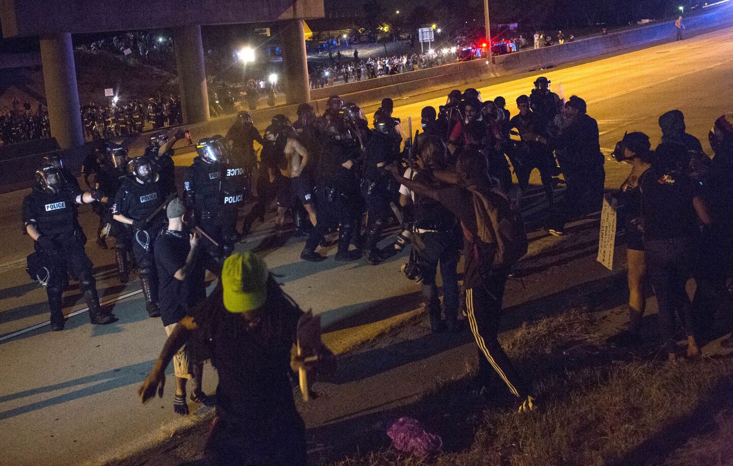 Police use pepper spray and tear gas to force protesters off Interstate 277 on Thursday.