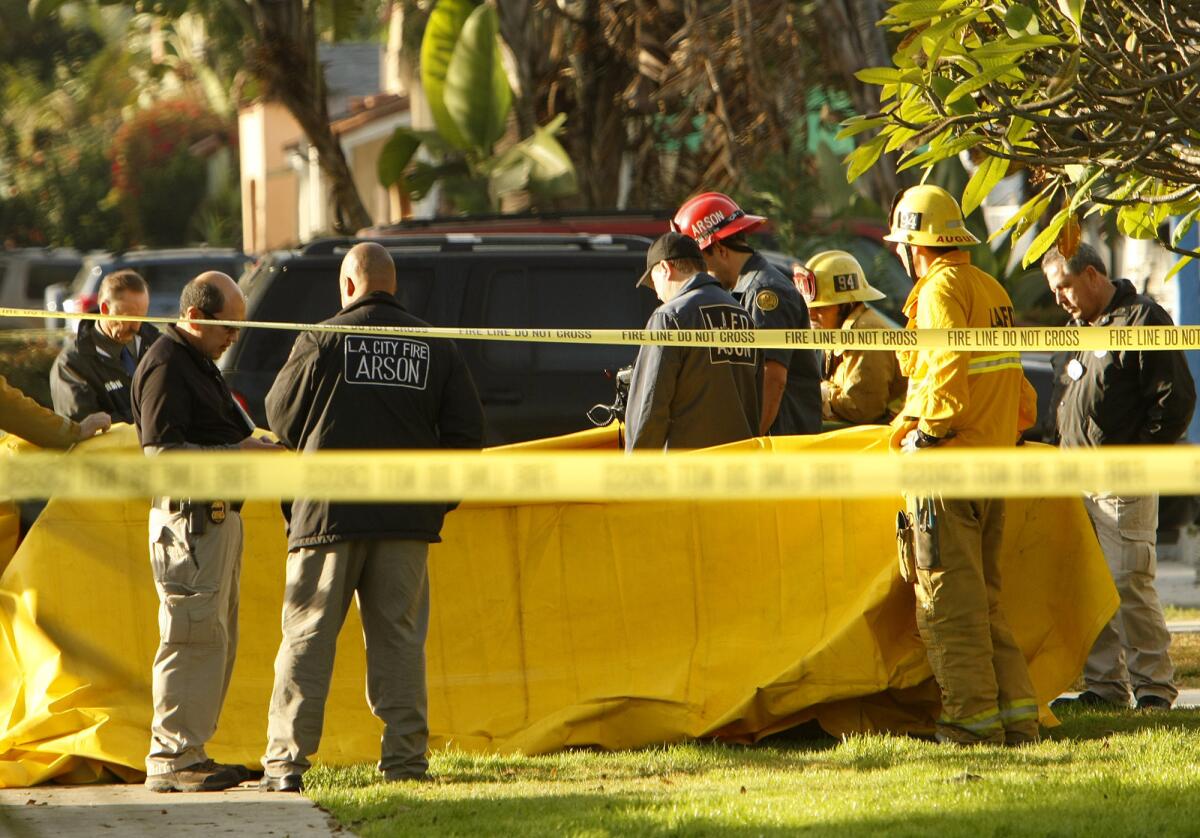 Investigators at the site of a house fire Tuesday in Mid-City that left a 36-year-old man dead.