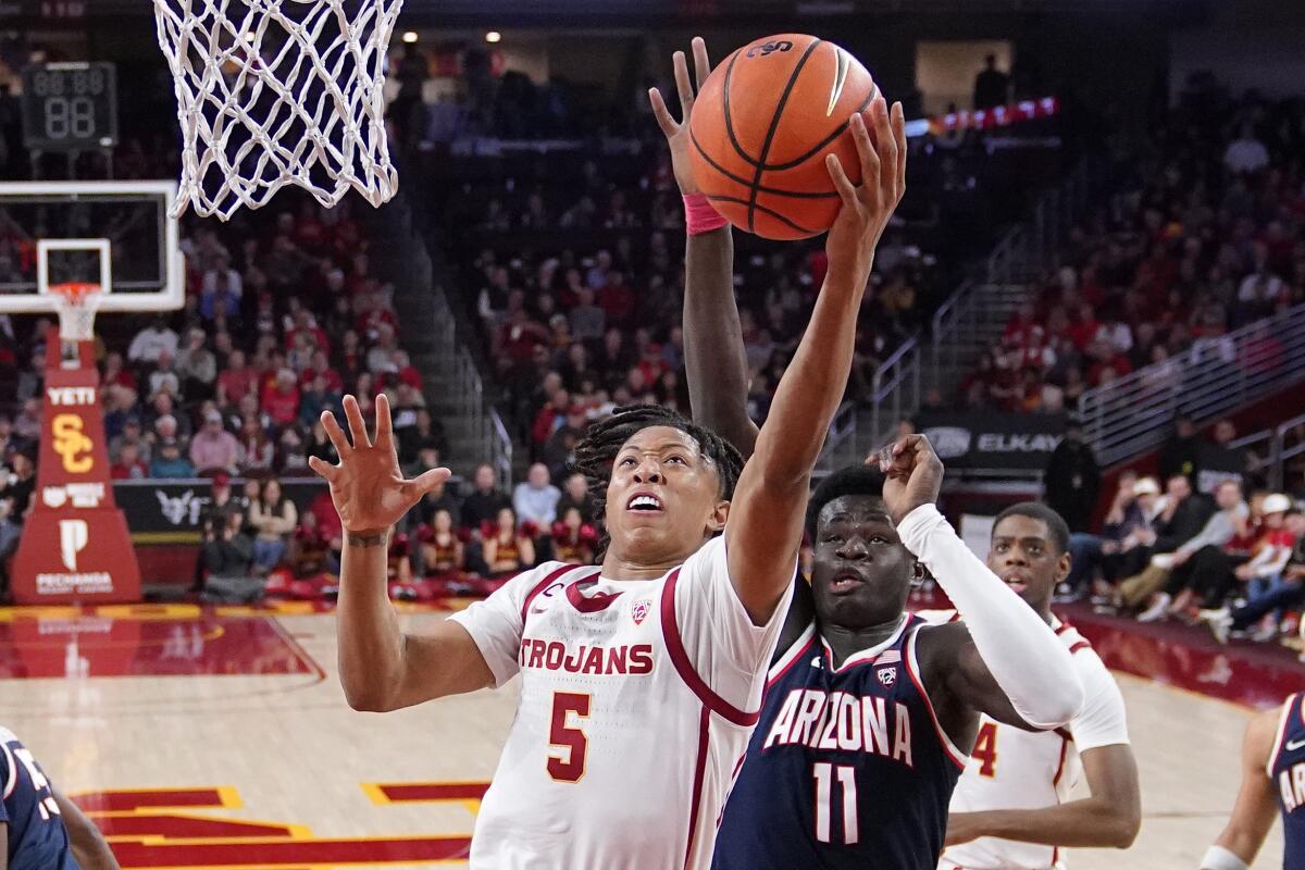 USC guard Boogie Ellis shoots as Arizona center Oumar Ballo defends.