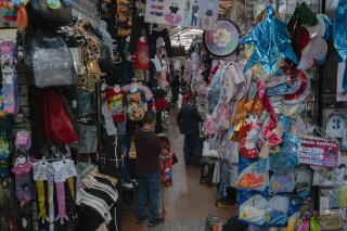A man fixes a Spider-Man costume at the San Jacinto popular market in Caracas.