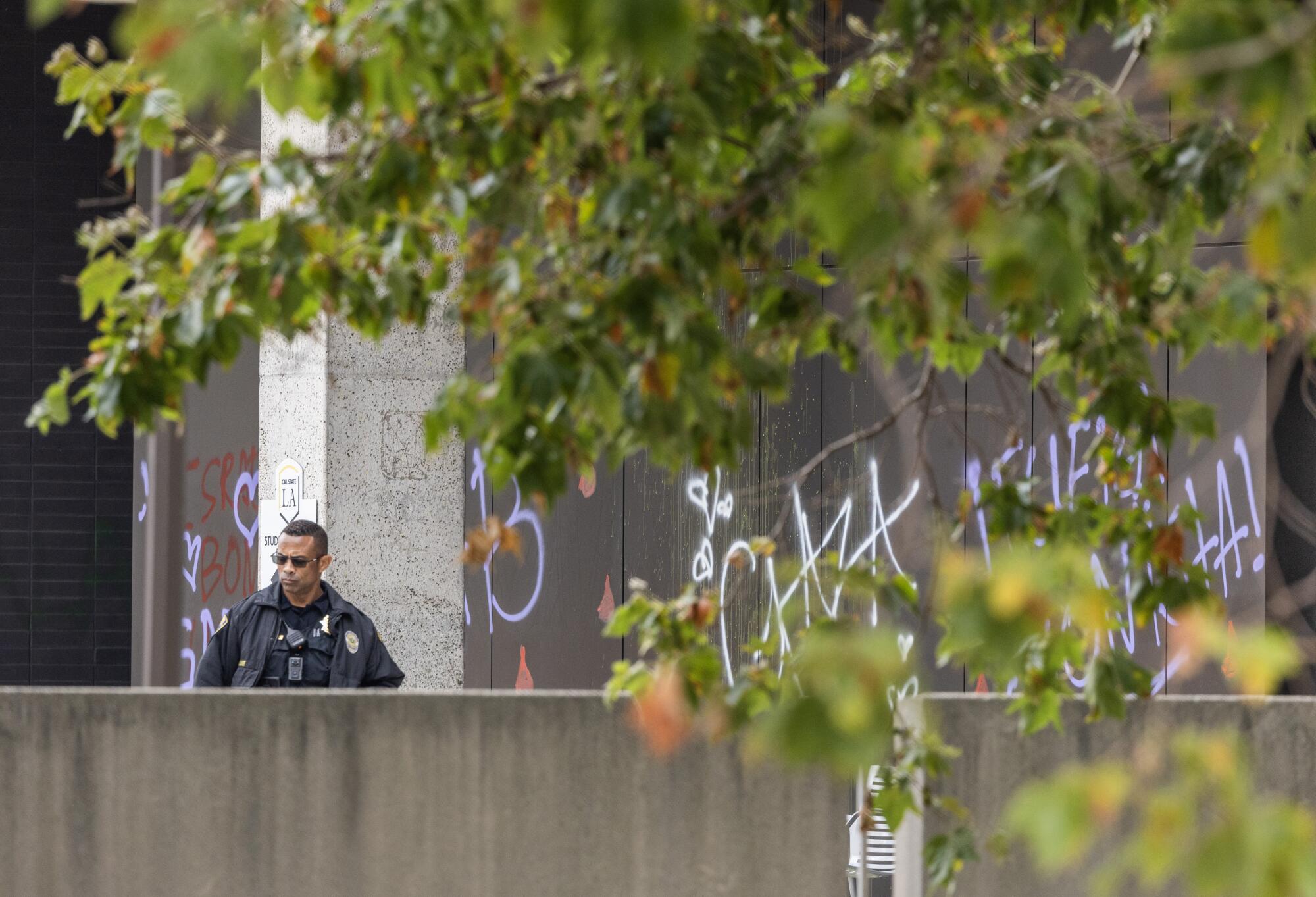 A police officer stands watch outside the student services building at Cal State Los Angeles.