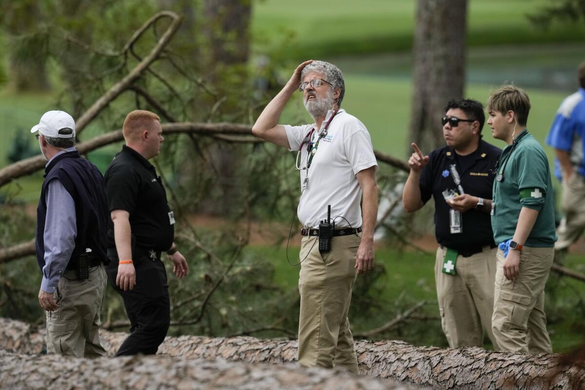 Authorities investigate the scene where trees fell on the 17th hole during the second round of the Masters on Friday.