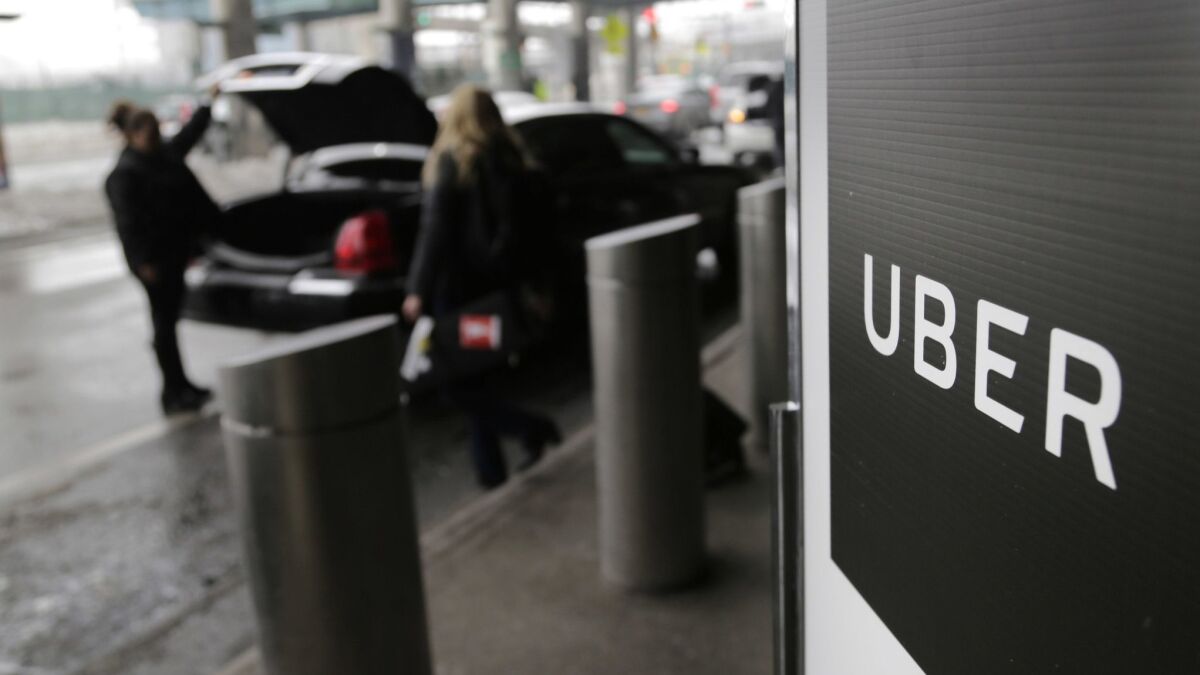 A sign marks a pickup point for the Uber car service at LaGuardia Airport in New York. Ride-hailing giant Uber has filed confidential preliminary paperwork for selling stock to the public.