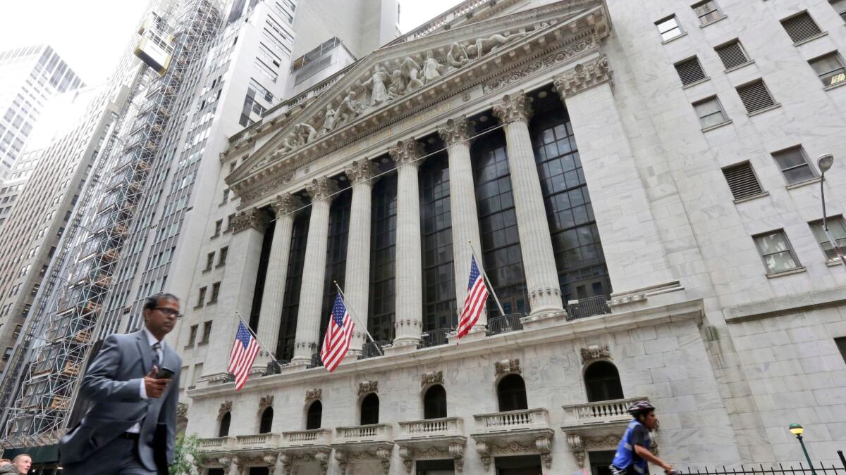 People pass the New York Stock Exchange.