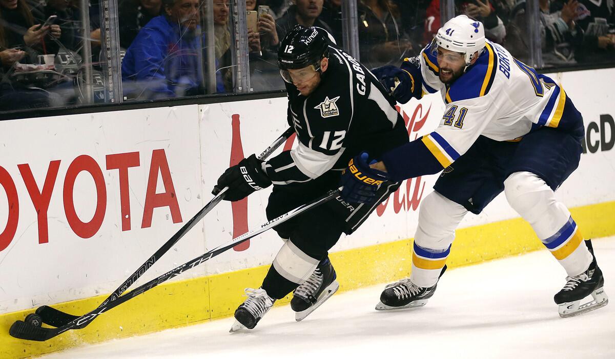 Kings winger Marian Gaborik (12) and St. Louis Blues defenseman Robert Bortuzo (41) battle to control the puck during first period action at Staples Center on Thursday.