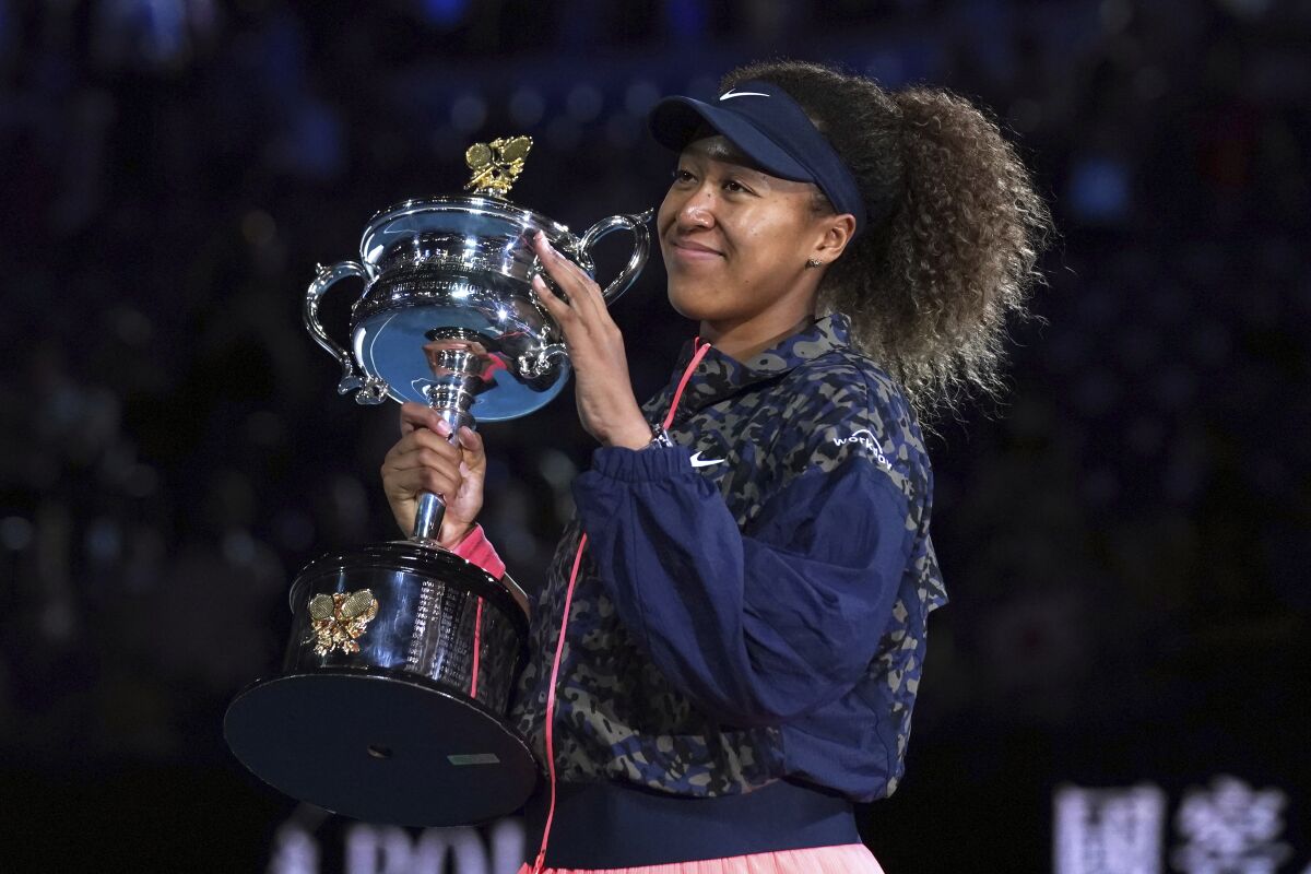 FILE - Japan's Naomi Osaka holds the Daphne Akhurst Memorial Cup after defeating United States Jennifer Brady in the women's singles final at the Australian Open tennis championship in Melbourne, Australia, in this Saturday, Feb. 20, 2021, file photo. Naomi Osaka was going to be at the center of attention during the Tokyo Olympics no matter what. She is a tennis superstar who owns four Grand Slam titles and is the highest-earning female athlete in the world.(AP Photo/Mark Dadswell, FIle)