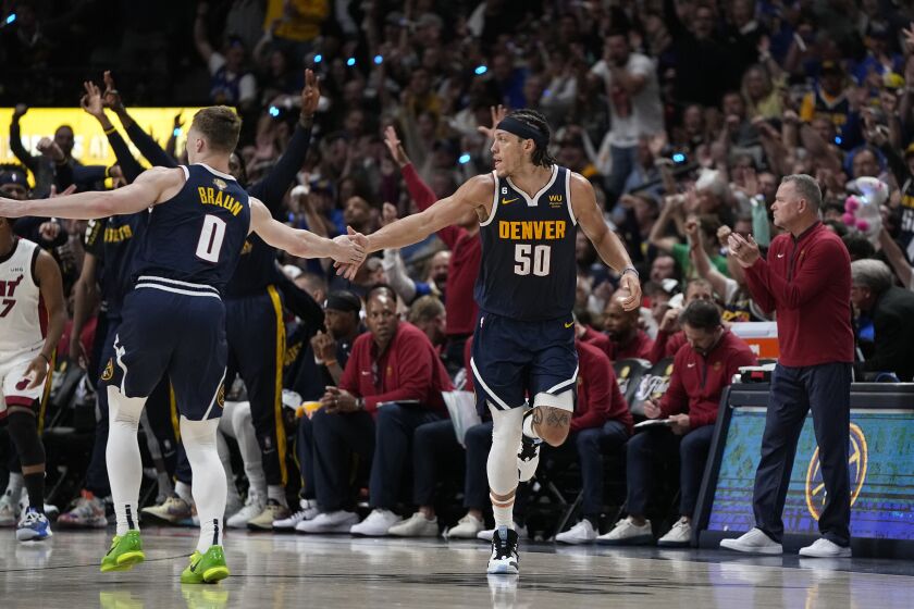 Denver Nuggets forward Aaron Gordon (50) celebrates with guard Christian Braun (0) after scoring against the Miami Heat during the first half of Game 2 of basketball's NBA Finals, Sunday, June 4, 2023, in Denver. (AP Photo/Mark J. Terrill)