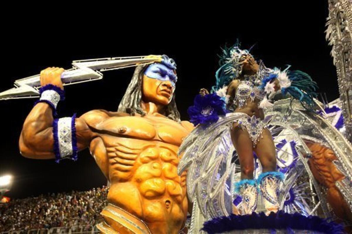 A member of Beija Flor samba school performs on a float during carnival celebrations at the Sambadrome in Rio de Janeiro, early Monday, Feb.15, 2010. (AP Photo/Martin Mejia) — AP
