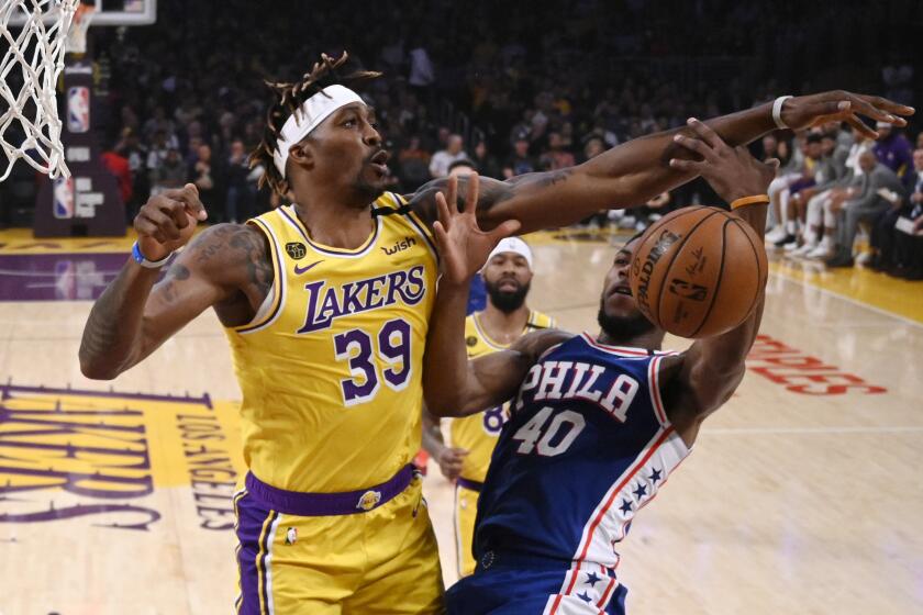 Los Angeles Lakers center Dwight Howard, left, blocks the shot of Philadelphia 76ers forward Glenn Robinson III.