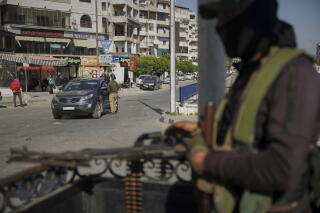 Syrian security forces inspect vehicles at a checkpoint in Latakia, in the country's coastal region.