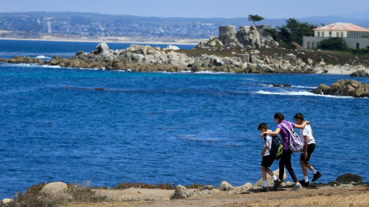Tourists explore the rocky shoreline of Pacific Grove, a small town located on Monterey Bay.