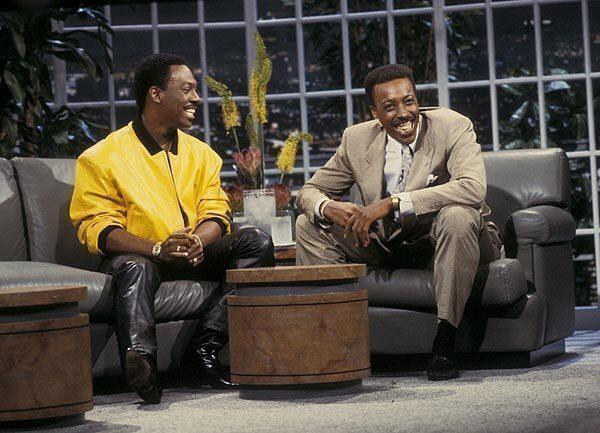 "Coming to America" costars Eddie Murphy and Arsenio Hall pal around on the set of the syndicated "The Arsenio Hall Show" (1989-1994).