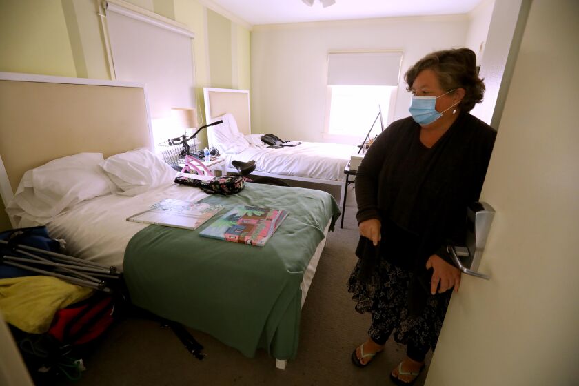 VENICE, CA - JUNE 1, 2020 - - Wendy Brown, 58, enters her room at the Cadillac Hotel in Venice on June 1, 2020. Brown spent three years sleeping on Venice sidewalks. Now as part of the Project Roomkey response to COVID-19 pandemic she is sleeping in a $240 a night room off the Venice boardwalk, taking daily runs and painting. But she wonders why the city before the pandemic offered homeless people everything but housing. Project Roomkey is a coordinated effort by the Los Angeles Homeless Services Authority to secure hotel and motel rooms in L.A. County as temporary shelters for people experiencing homelessness who are at high-risk for hospitalization if they contract COVID-19. (Genaro Molina / Los Angeles Times)