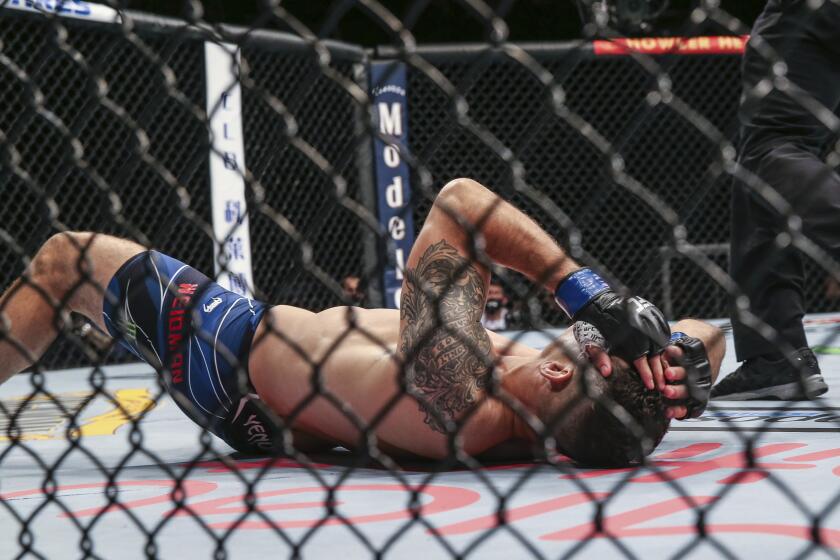 Chris Weidman on the canvas with a broken leg ending his UFC 261 mixed martial arts fight, Saturday, April 24, 2021, in Jacksonville, Fla. This is the first UFC event since the onset of the COVID-19 pandemic to feature a full crowd in attendance. (AP Photo/Gary McCullough)