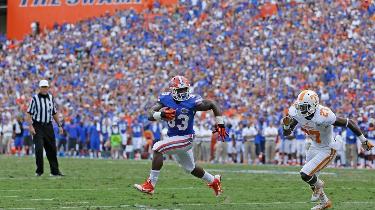 Florida running back Mack Brown (33) runs a three-yard touchdown past Tennessee defensive back Justin Coleman (27) during the first half in Gainesville, Fla. on Sept. 21, 2013.