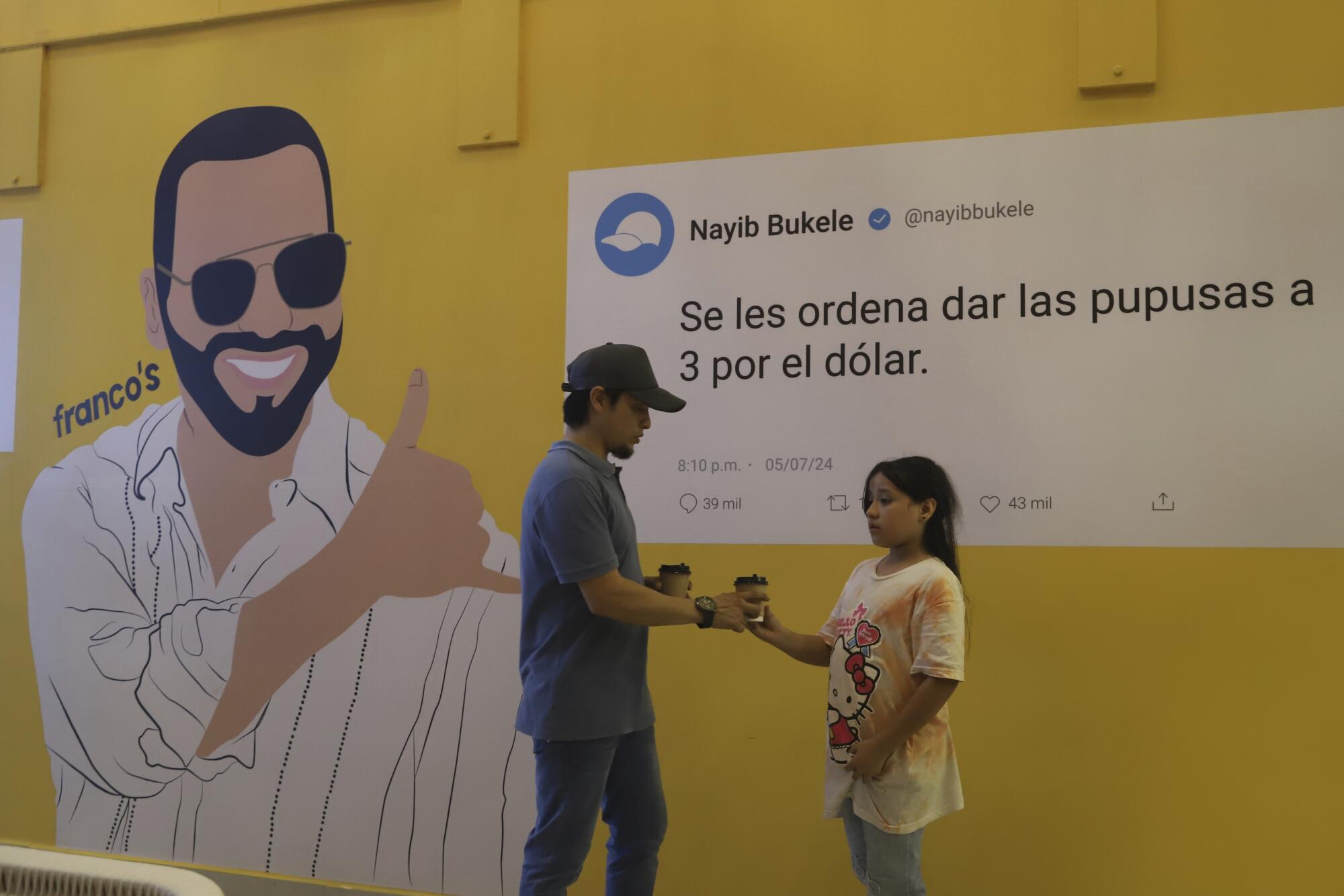 A couple stands in front of a political mural depicting President Nayib Bukele.