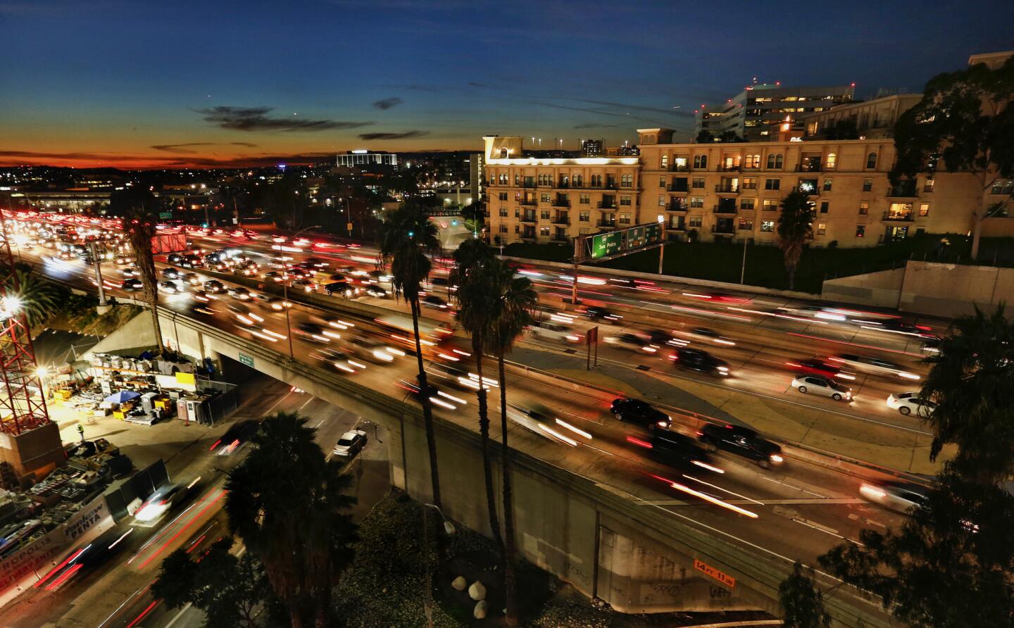 Cars move along the 110 freeway in downtown Los Angeles, past the Medici apartments, one of developer Geoffrey H. Palmer’s complexes overlooking downtown freeways. More than 1.3 million people live in high-pollution zones within 500 feet of a Southern California freeway and thousands more are moving there each year.