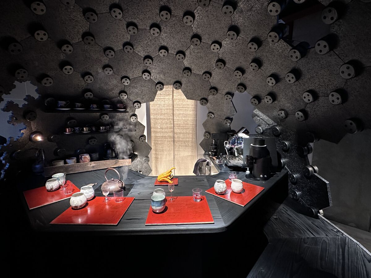 A table set for coffee service in the interior of a sculptural black orb
