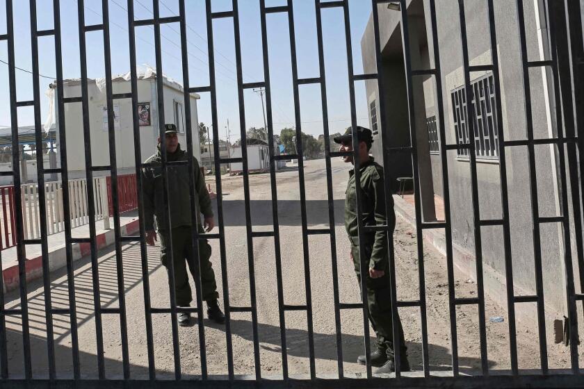 Palestinian security forces loyal to the Palestinian Authority (L) stand at the gate of the Kerem Shalon crossing, the main passage point for goods entering Gaza, after is was closed by Israel following the discovery of smuggling tunnels underneath the crossing, in the southern Gaza Strip town of Rafat on January 14, 2018. / AFP PHOTO / SAID KHATIBSAID KHATIB/AFP/Getty Images ** OUTS - ELSENT, FPG, CM - OUTS * NM, PH, VA if sourced by CT, LA or MoD **