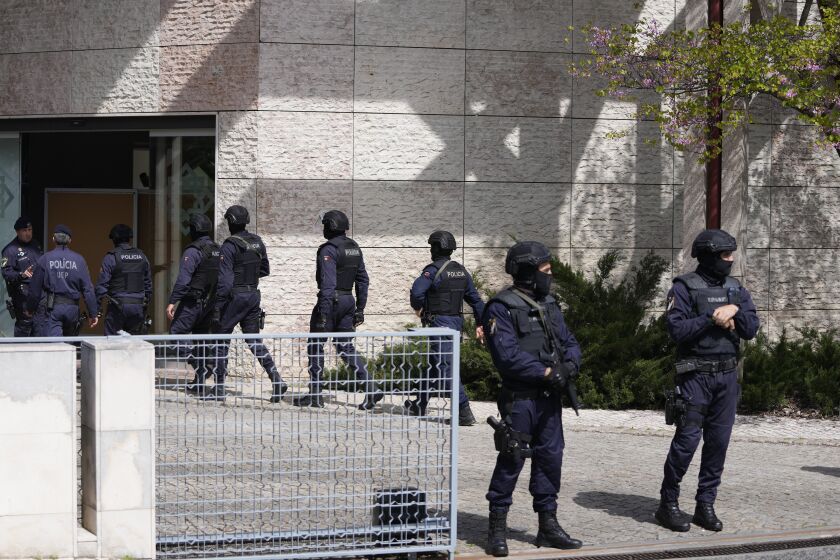 Police officers stand at the main entrance of an Ismaili Muslim center in Lisbon, Portugal, Tuesday, March 28, 2023. Portuguese police have shot a man suspected of stabbing two people to death at an Ismaili Muslim center in Lisbon. Authorities said police were called to the center late Tuesday morning where they encountered a suspect armed with a large knife. (AP Photo/Armando Franca)