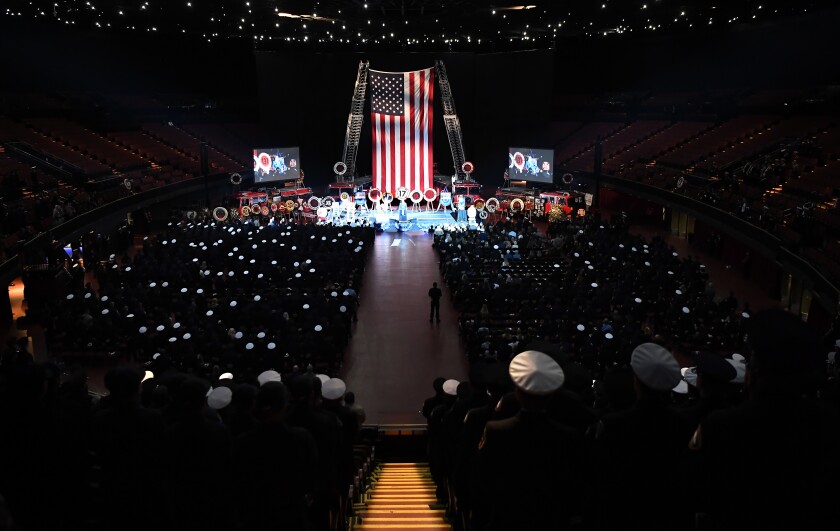 An American flag hangs inside the Forum as a crowd looks on
