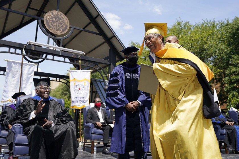 A Jackson State member of the Class of 1970 laughs after being handed a diploma during an official graduation ceremony, as one of 74 graduates honored by the historically black university, Saturday, May 15, 2021, at the Jackson, Miss., historically black university. The graduates were bestowed diplomas, 51 years after the school canceled its 1970 graduation ceremony after white law enforcement officers marched onto campus near the end of the spring semester and violently suppressed protests against racism with gunfire, killing two and wounding 12, on May 15, 1970. (AP Photo/Rogelio V. Solis)