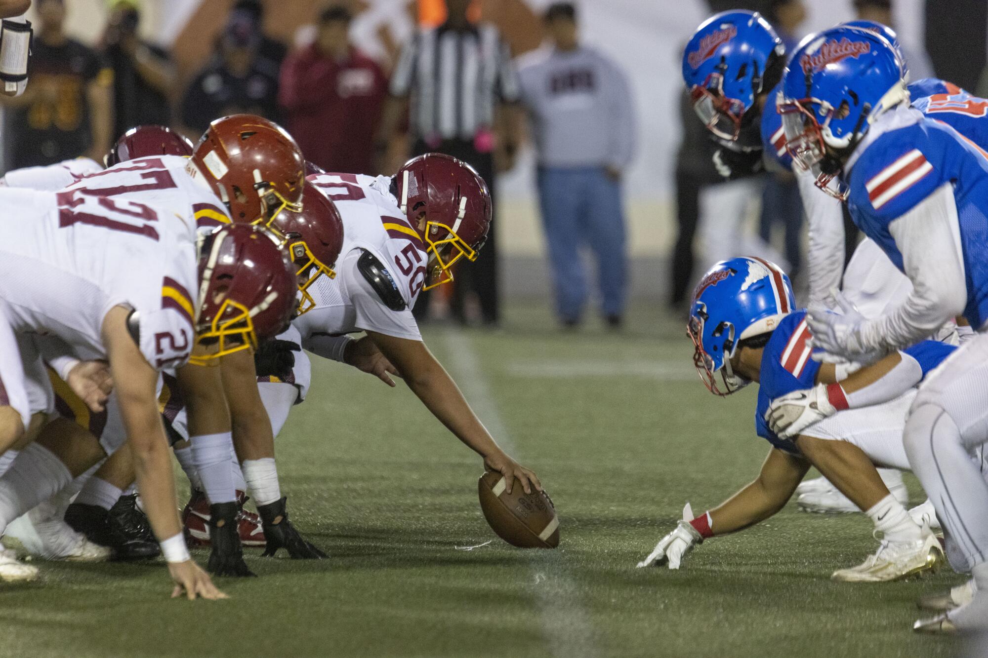 Two high school football teams on the line of scrimmage 
