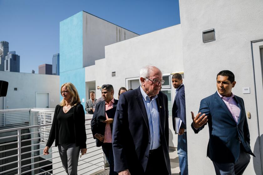 LOS ANGELES, CALIF. -- TUESDAY, AUGUST 6, 2019: Senator Bernie Sanders tours the Star Apartments housing in Skid Row area of downtown Los Angeles, Calif., on Aug. 6, 2019. On his right is Assemblymember Miguel Santiago and to his left is Cheri Todoroff, Housing for Health. (Marcus Yam / Los Angeles Times)