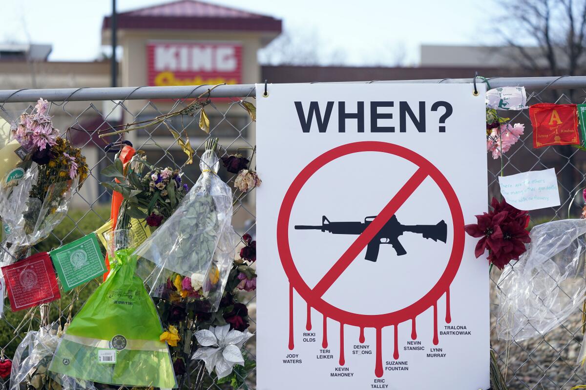 Flowers and gun-control poster hanging on a fence