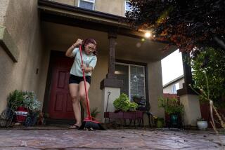 VICTORVILLE, CA - JULY 5, 2023: Gladis Avila still finds time to sweep her front porch after commuting five days a week from her home in Victorville to her job as a housekeeper at the W hotel in Hollywood on July 5, 2023 in Victorville, California. She lives in Victorville with her husband and three children.(Gina Ferazzi / Los Angeles Times)