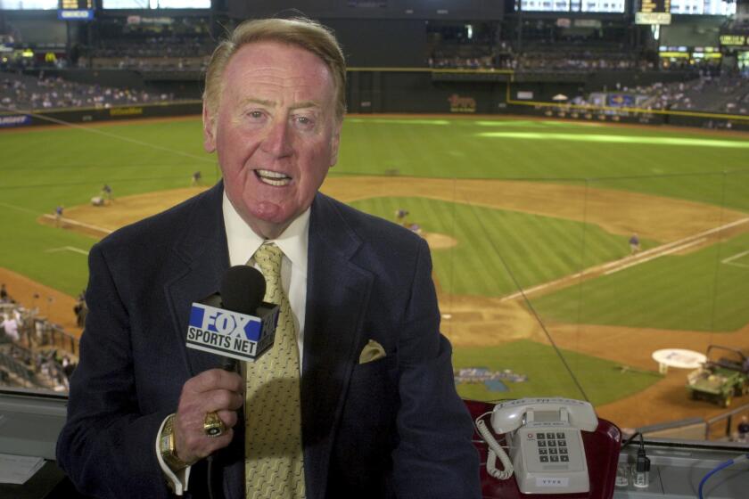 FILE - Los Angeles Dodgers television play-by-play announcer Vin Scully rehearses before a baseball game 