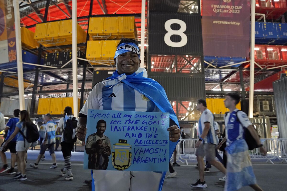 Un aficionado argentino procedente Singapur aguarda afuera del estadio 974 previo al partido entre Polonia y Argentina