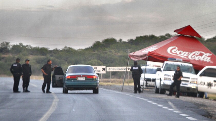 Mexican police operate a checkpoint on the highway that follows the Rio Grande River outside Reynosa.