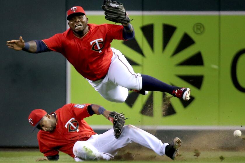 Twins right fielder Miguel Sano, top, and second baseman Eduardo Nunez collide in right field while chasing a fly ball hit by Angels third baseman Yunel Escobar during the fourth inning.