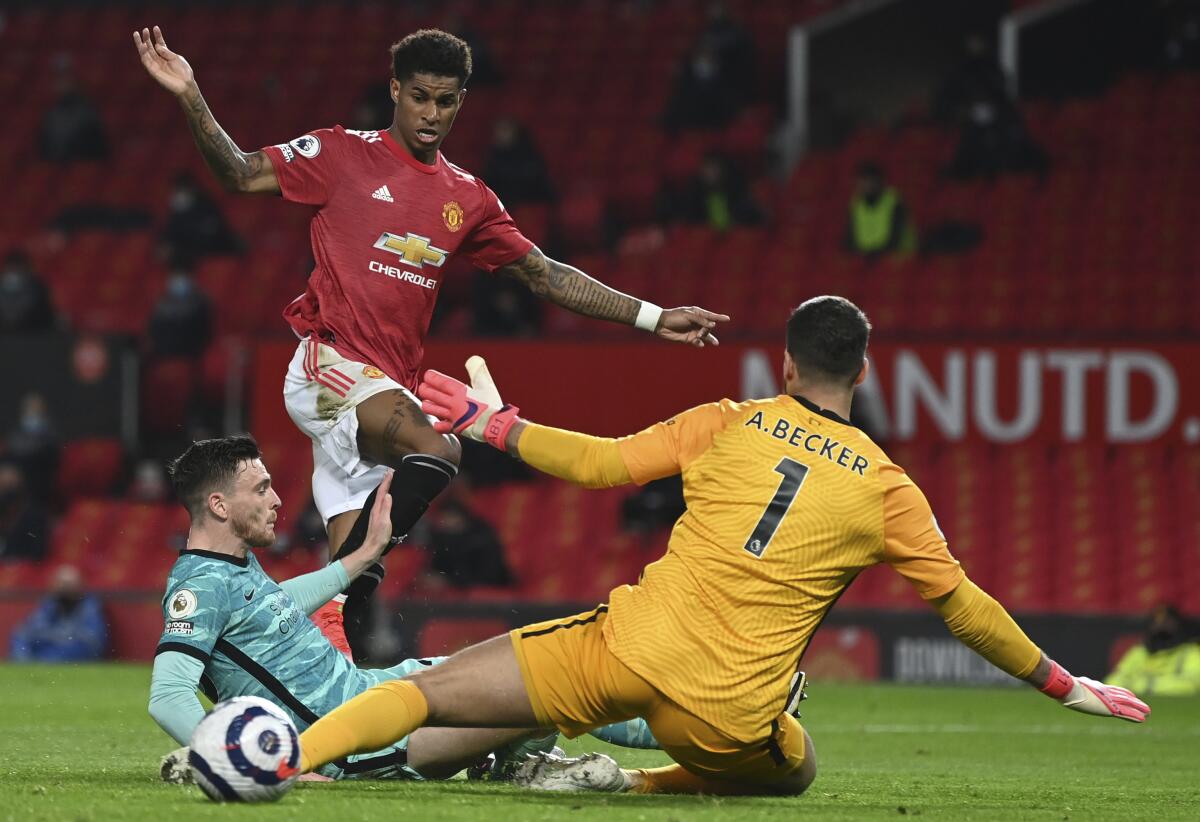 FILE - Manchester United's Marcus Rashford, top, scores his side's second goal during the English Premier League soccer match between Manchester United and Liverpool at the Old Trafford Stadium in Manchester, England, Thursday, May 13, 2021. New Jersey gambling regulators have fined two sports betting companies for mistakenly allowing 86 gamblers from New Jersey to place bets on whether Rashford would score a goal in the game after the game had already ended and Rashford had in fact scored. (Michael Regan/Pool Photo via AP, File)