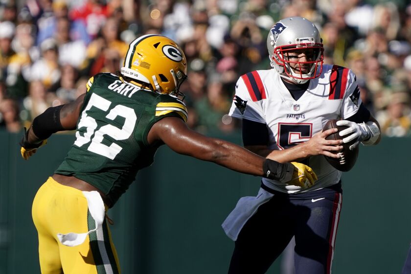 New England Patriots quarterback Brian Hoyer (5) is sacked by Green Bay Packers linebacker Rashan Gary (52) during the first half of an NFL football game, Sunday, Oct. 2, 2022, in Green Bay, Wis. (AP Photo/Morry Gash)