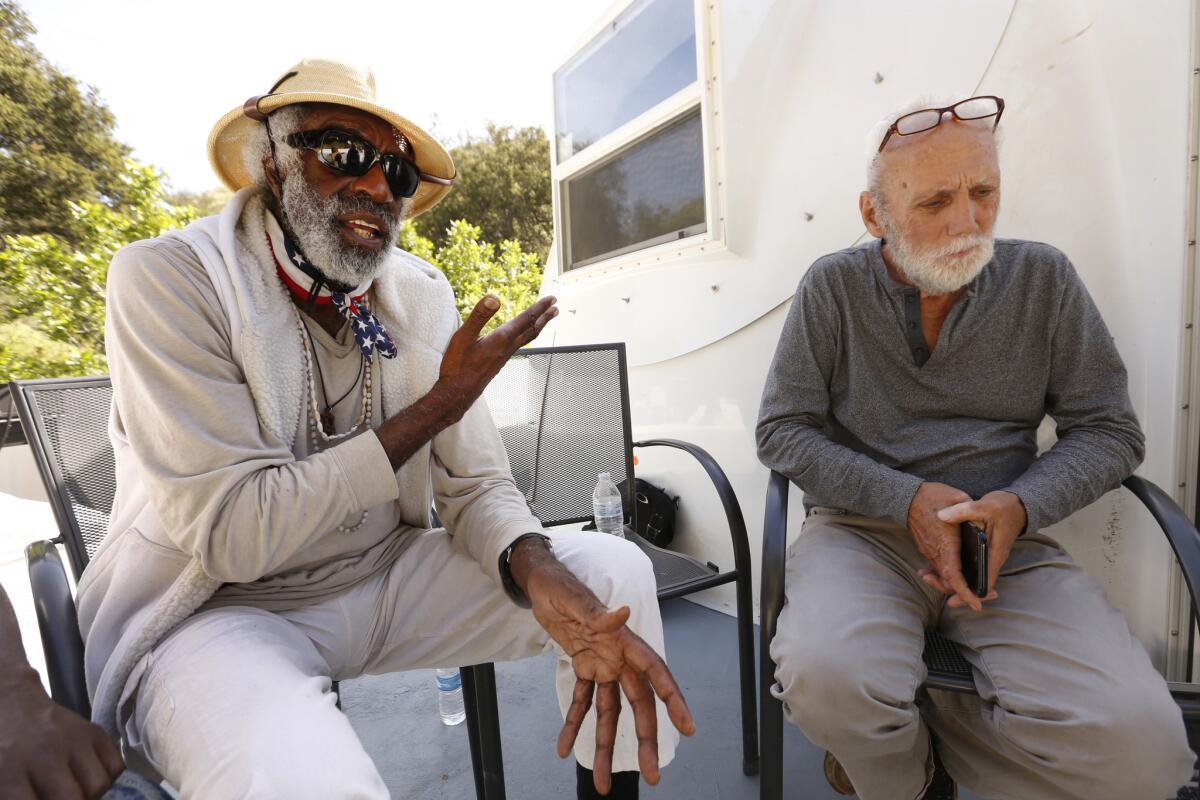 Activist for the homeless Ted Hayes, left, talks with Wayne Fishback in front of a prototype for a dome residence.