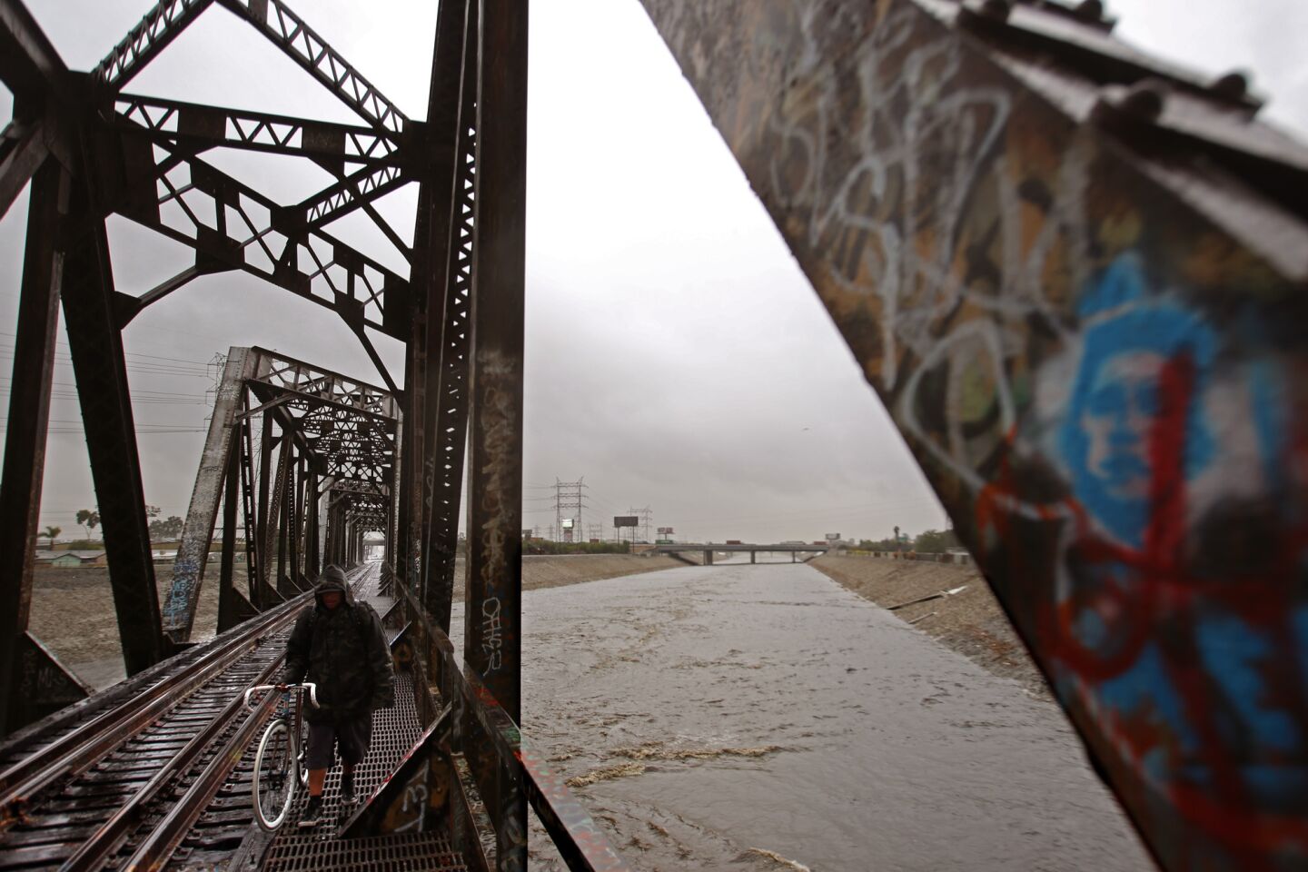 A man walks along an old Union Pacific Bridge as the Los Angeles River flows in South Gate.