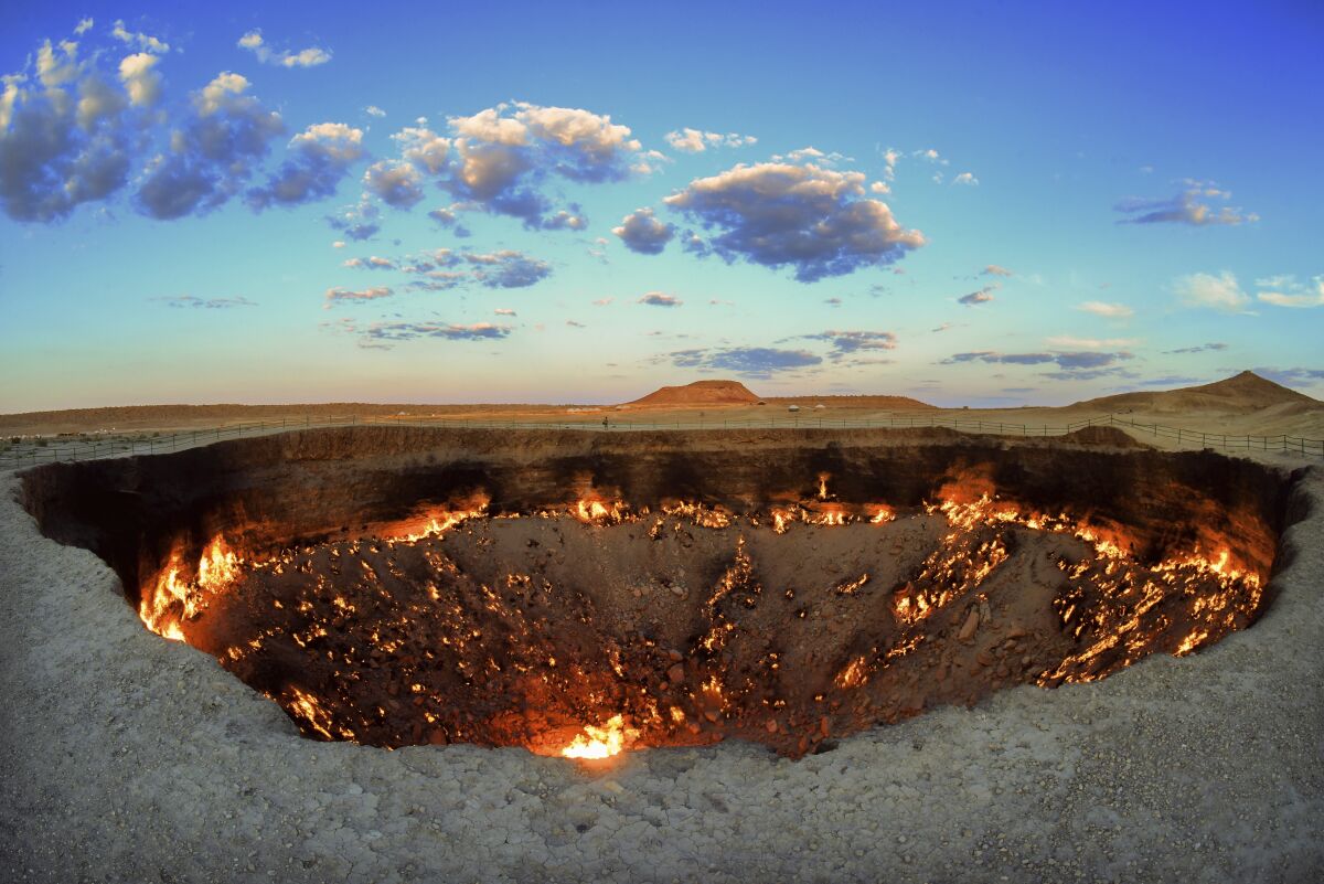 The crater fire named "Gates of Hell" is seen near Darvaza, Turkmenistan, Saturday, July 11, 2020. The president of Turkmenistan is calling for an end to one of the country's most notable but infernal sights — the blazing desert natural gas crater widely referred to as the “Gates of Hell.” The crater, about 260 kilometers (160 miles) north of the capital Ashgabat, has been on fire for decades and is a popular sight for the small number of tourists who come to Turkmenistan, which is difficult to enter. (AP Photo/Alexander Vershinin)