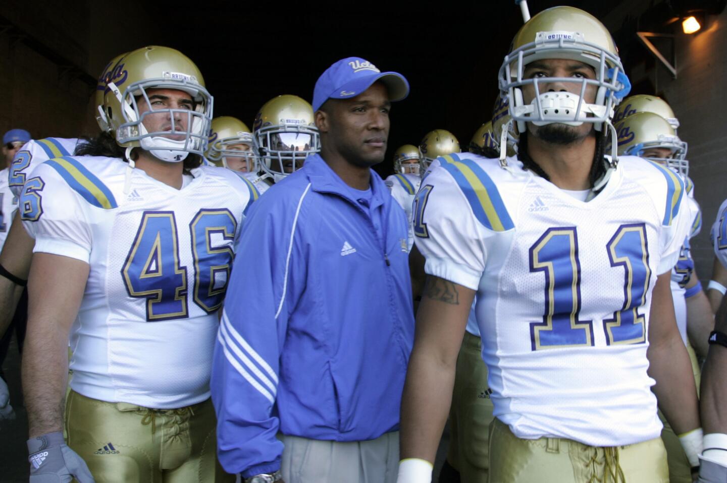 UCLA Coach Karl Dorrell comes out of the tunnel at the Coliseum with Chad Moline and Dennis Keyes to play the Trojans on Dec. 1, 2007.