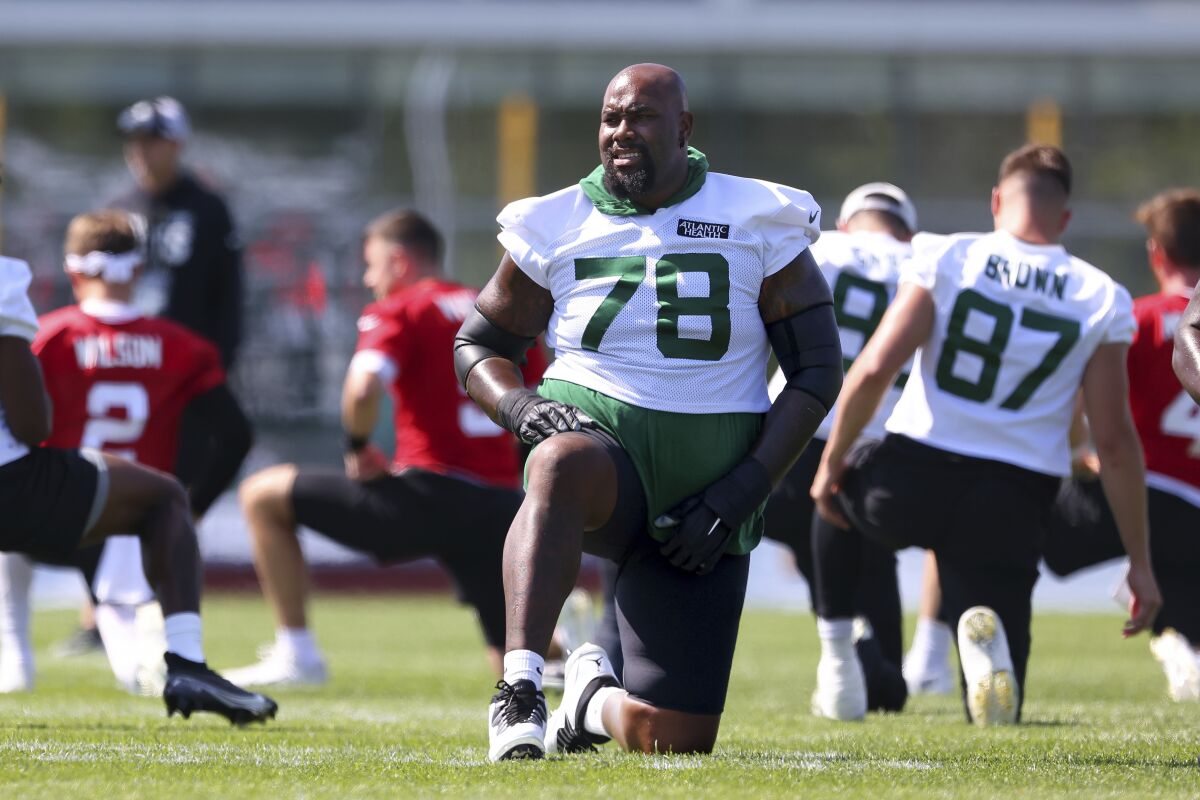 New York Jets offensive lineman Morgan Moses (78) stretches during practice at the team's NFL football training facility, Saturday, July. 31, 2021, in Florham Park, N.J. (AP Photo/Rich Schultz)
