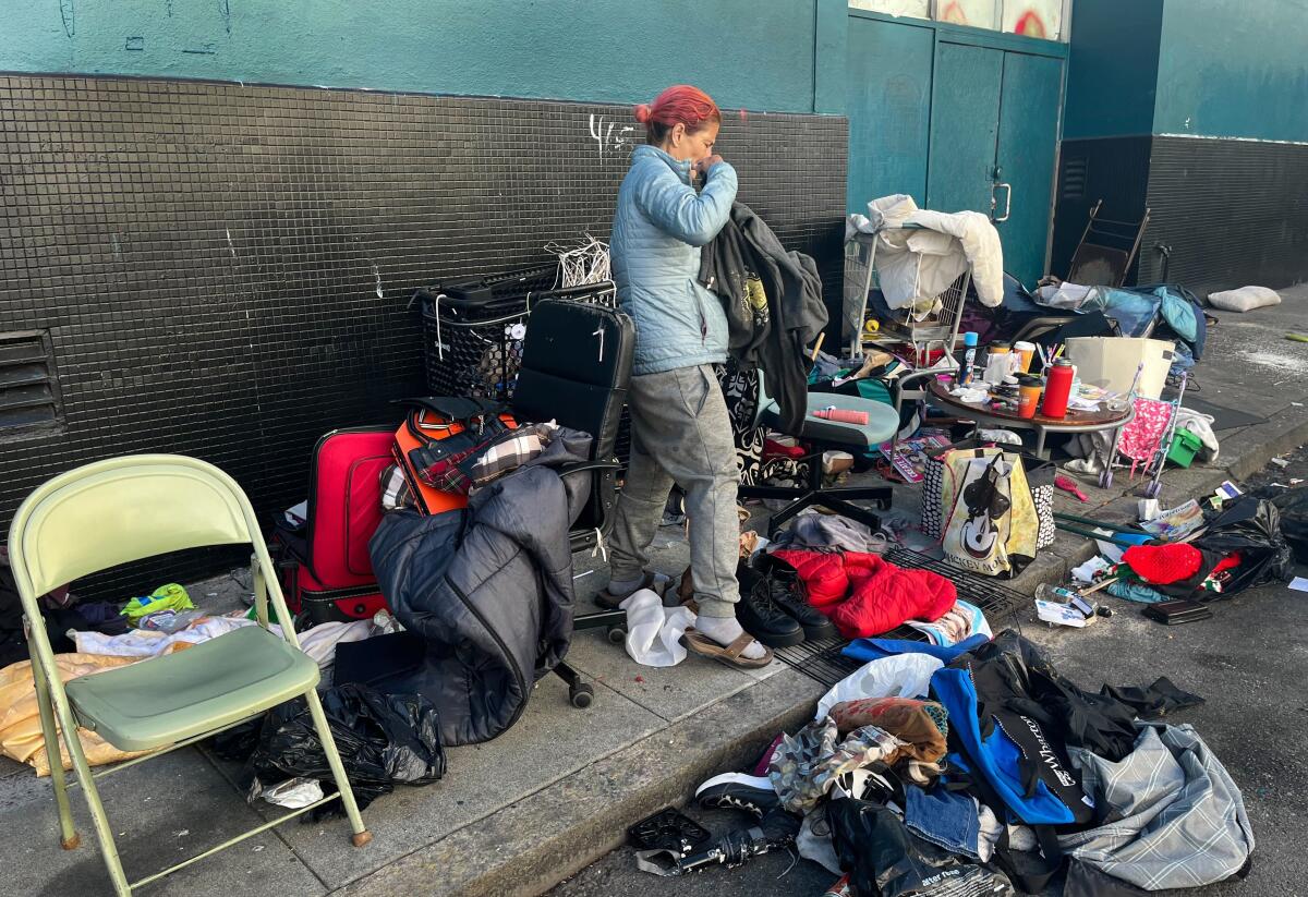 A woman sorts through piles of her belongings on the streets of San Francisco. 