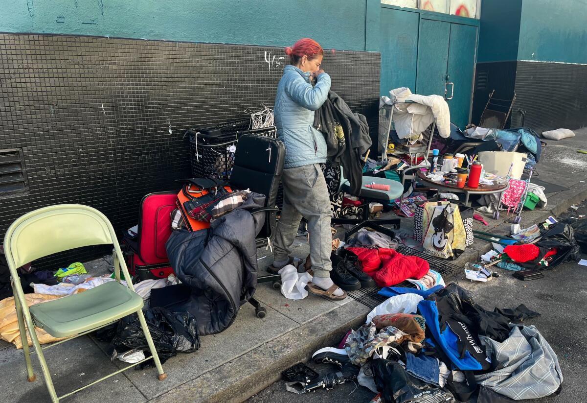 A woman sorts through piles of her belongings on the streets of San Francisco.
