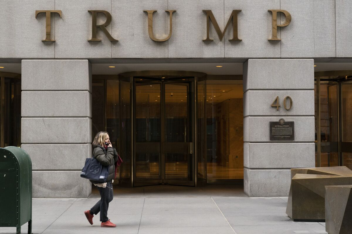A woman walks past the Trump Building in New York's financial district.