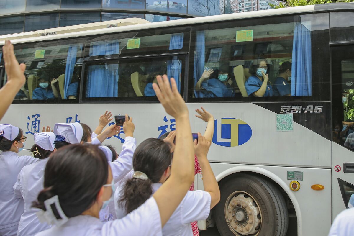 Medical workers send off their colleagues leaving to help with an outbreak of COVID-19 in Putian from a provincial hospital in Fuzhou in southeast China's Fujian province Sunday, Sept. 12, 2021. Putian, a city in southern China that is trying to contain a coronavirus outbreak told the public Sunday not to leave, suspended bus and train service and closed cinemas, bars and other facilities. (Chinatopix via AP)