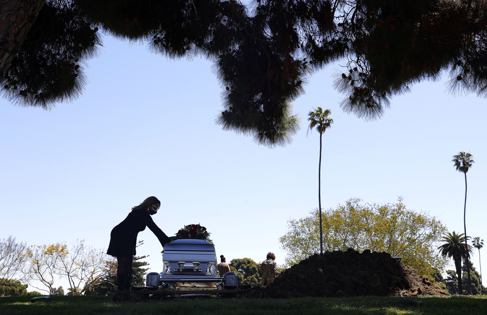 Clarice Kavanaugh places a hand on the casket of her friend Charles Jackson at Inglewood Park Cemetery. 